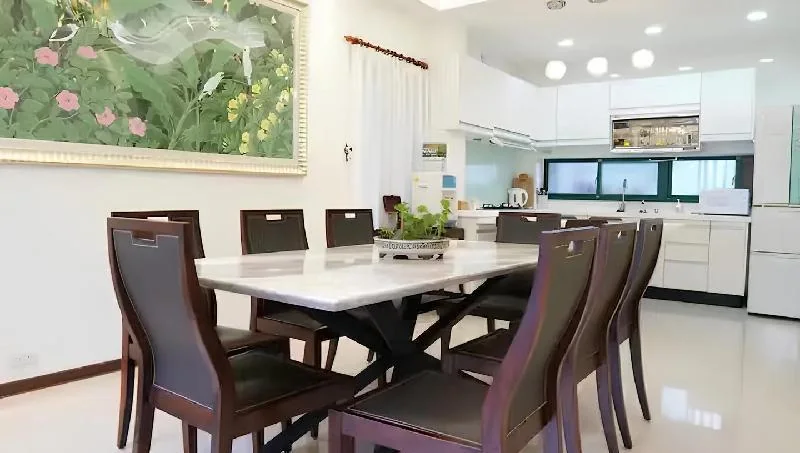 恰到好處餐桌與後方白色廚具