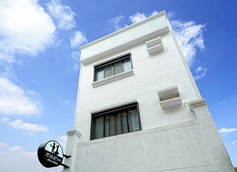 地球村國盛一街白色透天的日間外觀與圓形招牌
