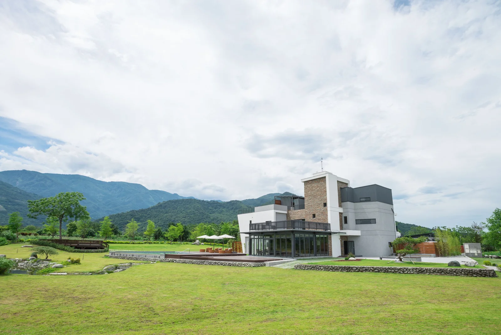 松邑莊園草地前的灰白建築，後方可見瑞穗山景