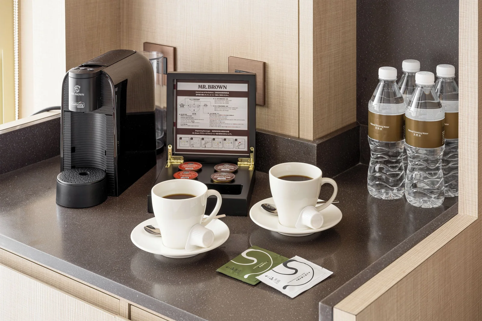 寒沐房內膠囊咖啡機、杯盤、瓶裝水及茶包